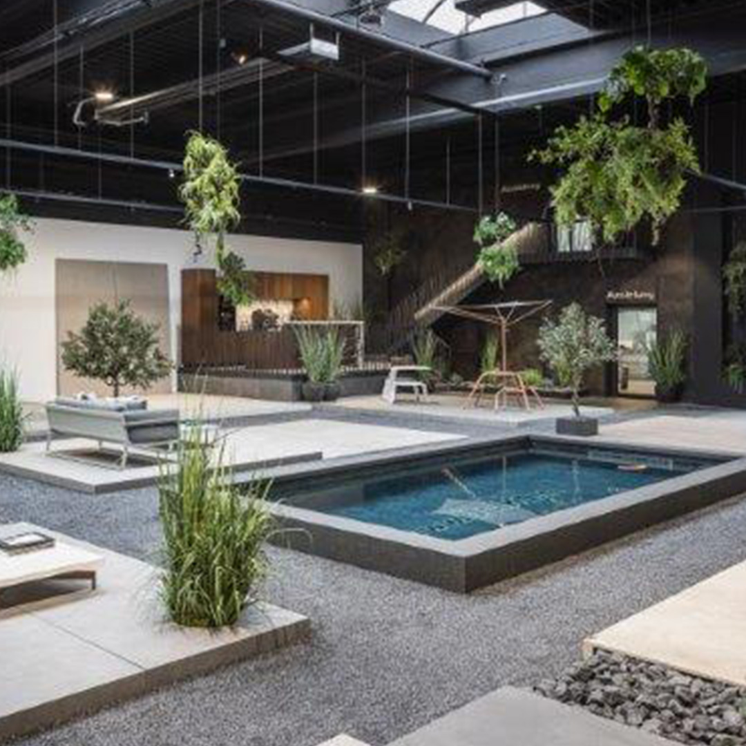 Moderne Innenraum-Landschaft mit Pool, Pflanzen und Lounge-Möbeln in neutralen Farben.