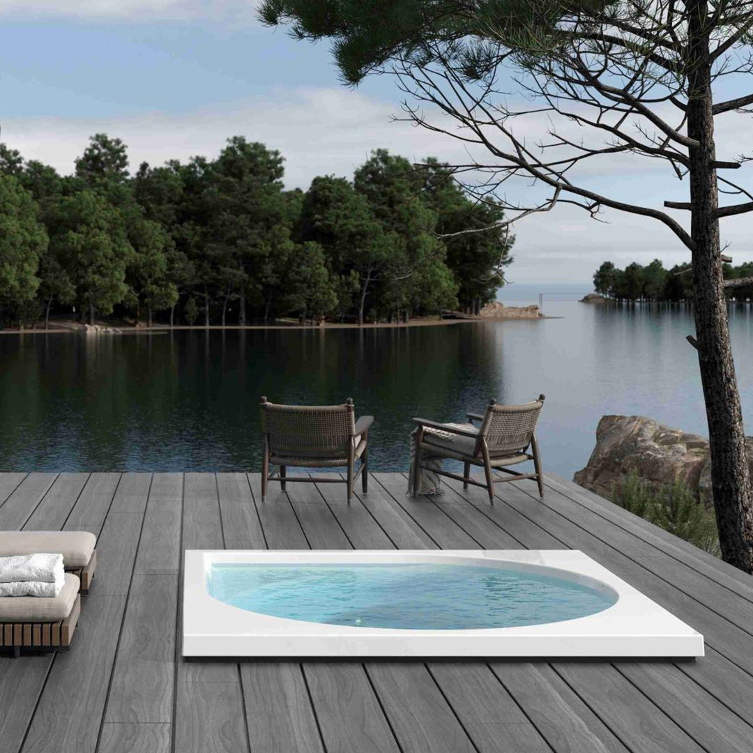 Eine Terrasse mit Whirlpool, Seeblick, Liegestühlen und Kieferbaum, ruhige und friedliche Stimmung.