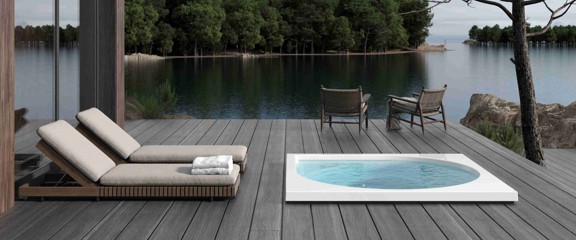 Sonnendeck mit zwei Liegen, kleinem Pool, See und Bäumen; moderne, ruhige Atmosphäre.