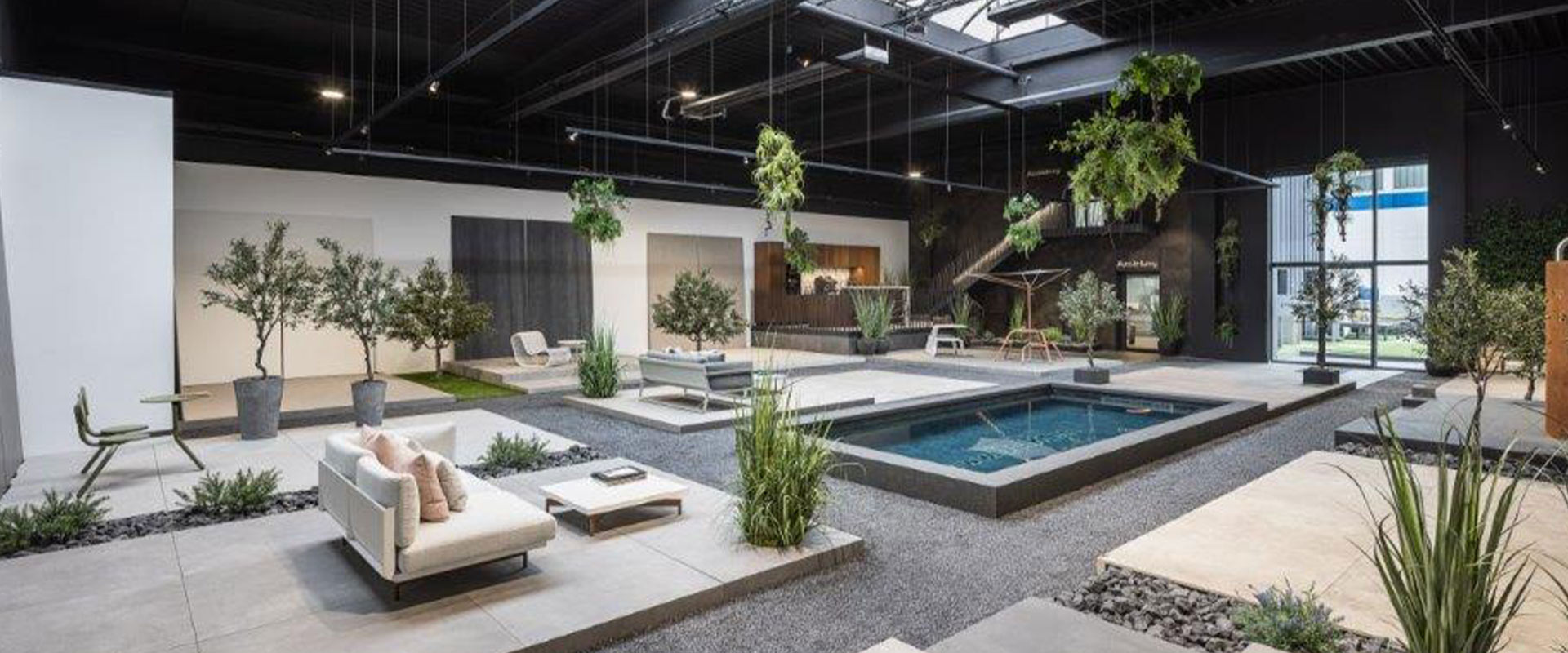 Modernes Interieur mit Indoor-Pool, Pflanzen und stilvollen Sitzmöbeln in neutralen Farben.