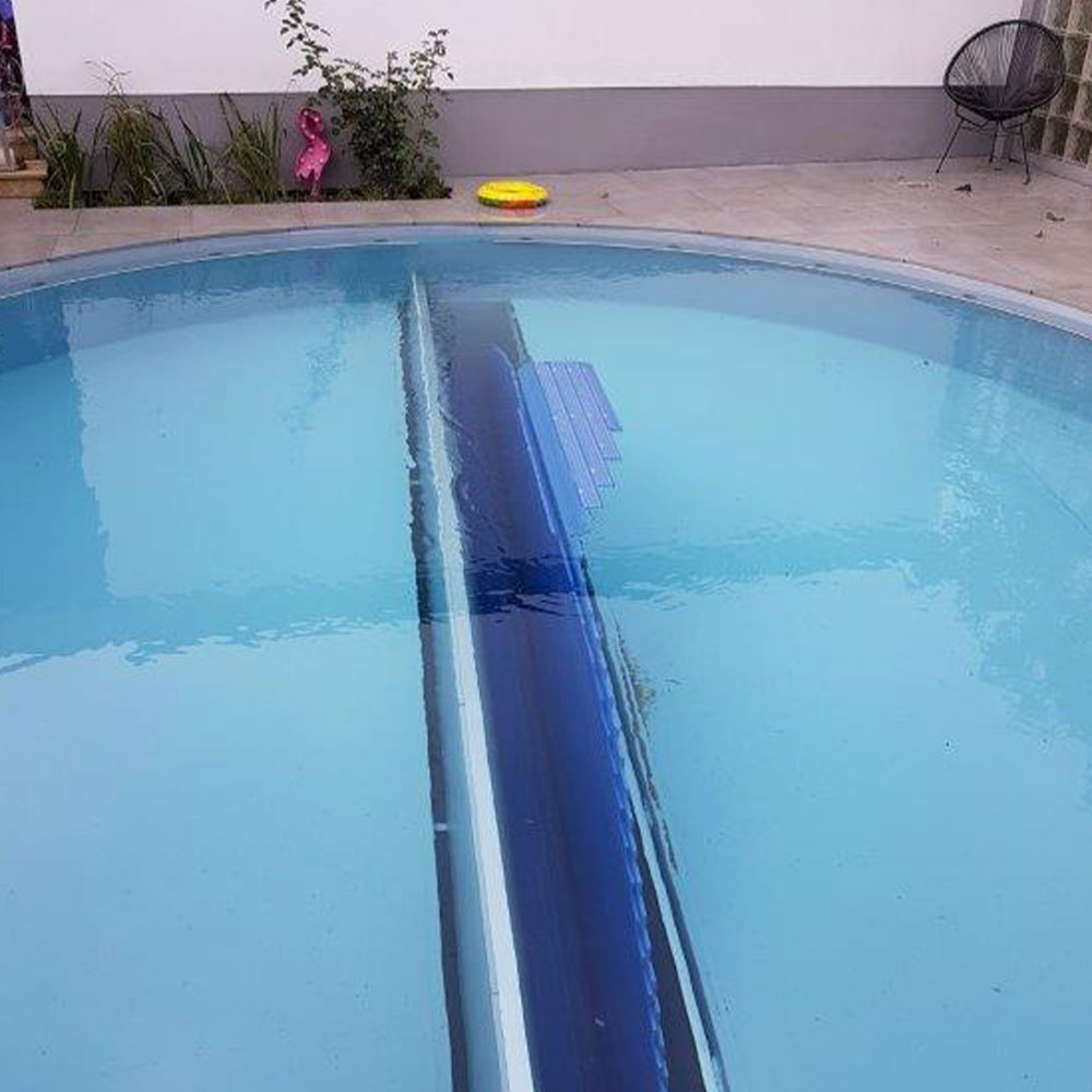 Ein halbgefüllter Pool mit einer automatischen blauen Abdeckung in der Mitte.