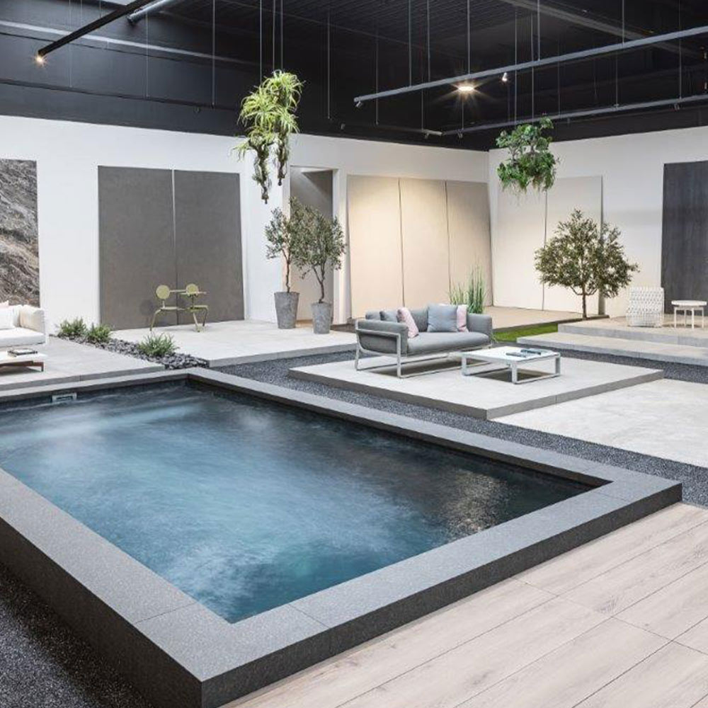 Moderner Innenraum mit kleinem, rechteckigem Pool und stilvollen Möbeln in Grau- und Weißtönen.