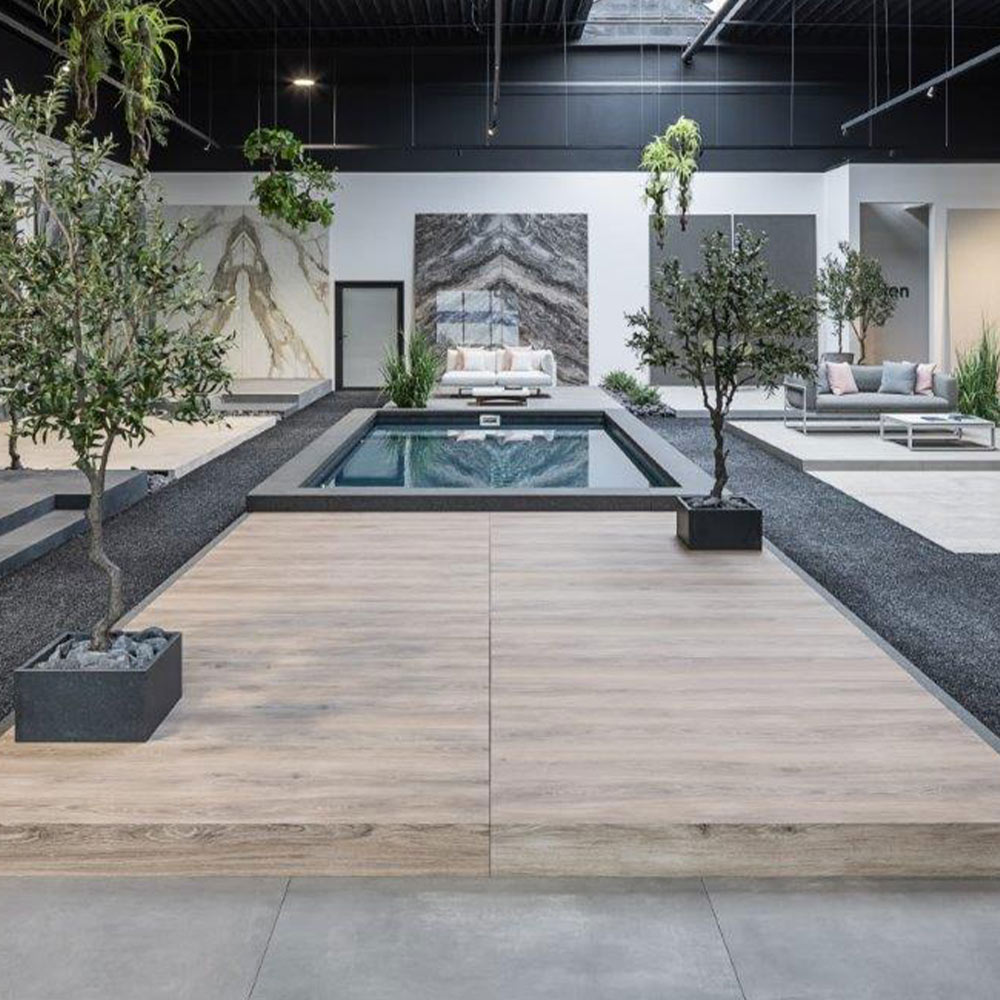 Innenraum mit modernem Design, kleinem rechteckigen Pool, Holzboden und kleinen Bäumen.